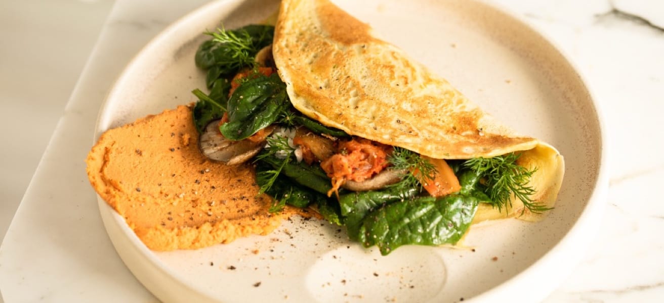 A plate of omelette with cheese and vegetables